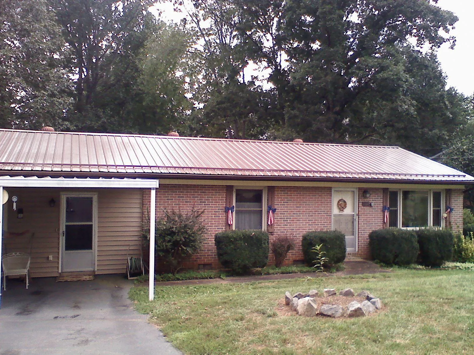 Bronze metal roof and carport on a brick ranch home — Roof Repair work by our crew in Sebastian